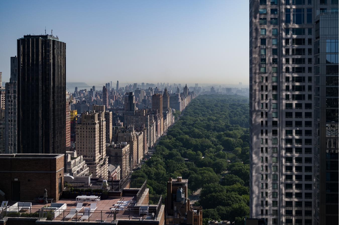 A high-floor view east across Central Park from a Columbus Circle apartment, terraces in foreground